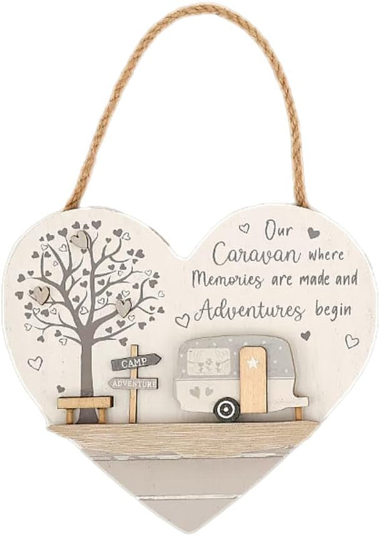 Heart-shaped wooden hanging wall plaque with a rope handle, featuring a tree, bench, signpost, and caravan illustration with the text 'Our Caravan where Memories are made and Adventures begin' on a white background.
