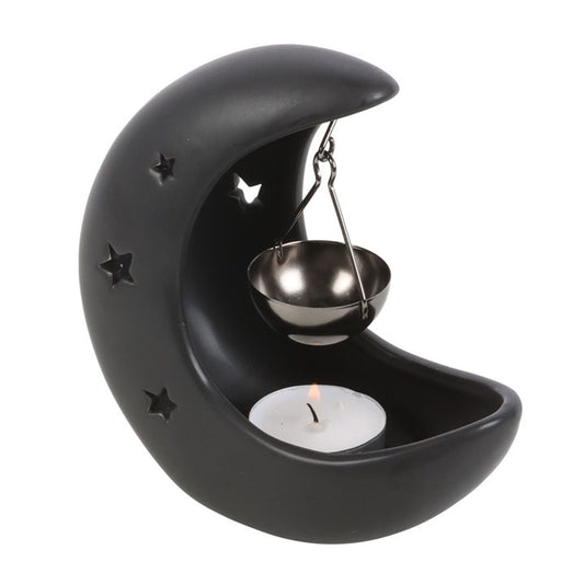 Black crescent moon oil burner with hanging metal ladle and lit tealight