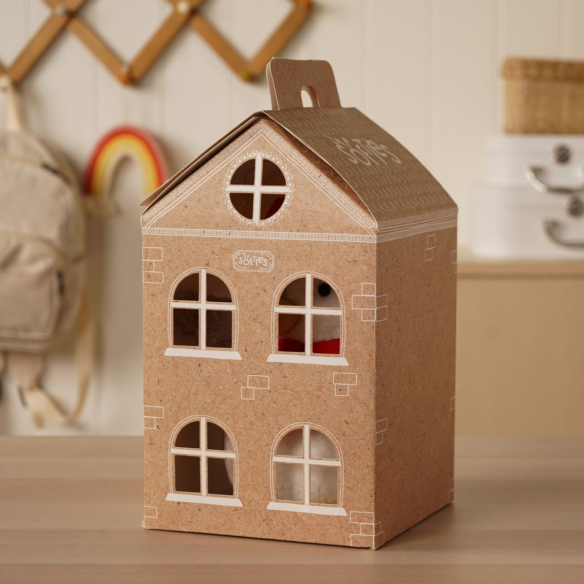 Gingerbread-style cardboard house decoration with windows, door, and hanging handle