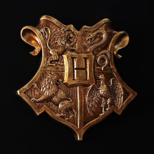 Gold-tone Harry Potter wall shield ornament with central emblem and house animal details