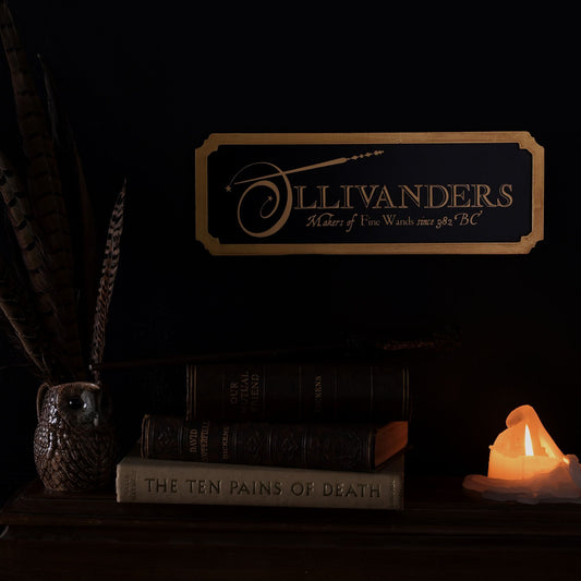 Ollivanders rectangular wall sign with black board and gold logo lettering