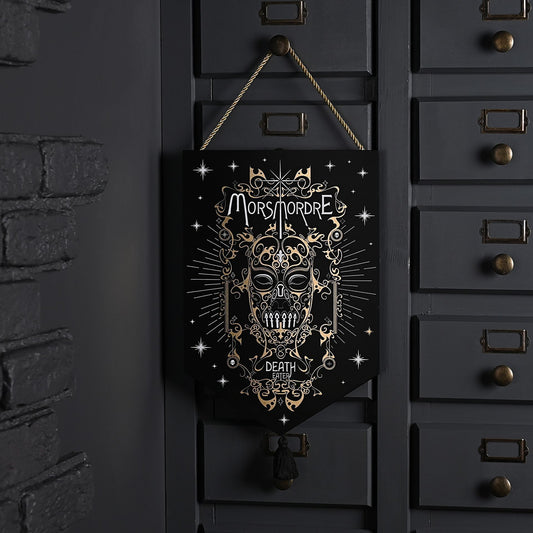 Hanging dark pendant with gold skull design, top loop, and short tassel