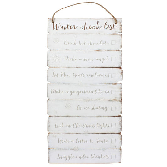 A rustic vertical wooden hanging sign with a jute rope loop at the top, featuring a white distressed finish and the words 'Winter check list' followed by holiday-themed checklist items in gray script with checkboxes.