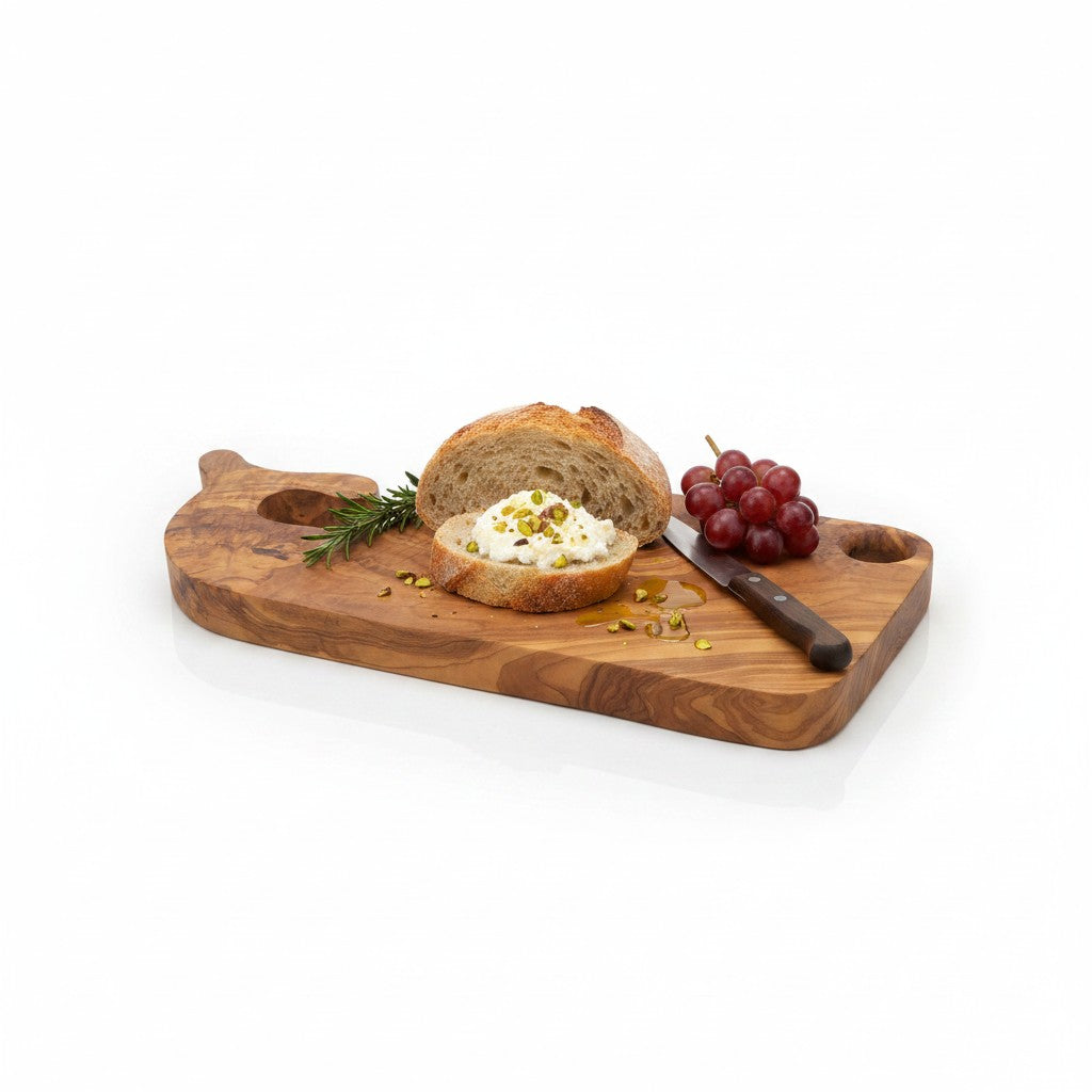 Fish-shaped wooden board with bread, dollop, grapes, rosemary, and small spice