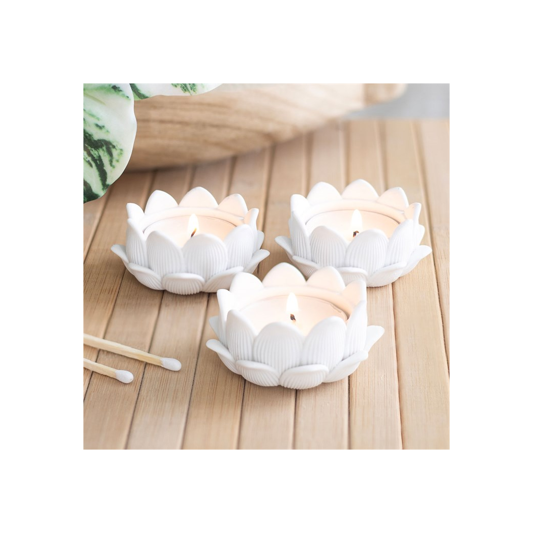 Set of 3 white lotus-shaped tealight holders with lit candles