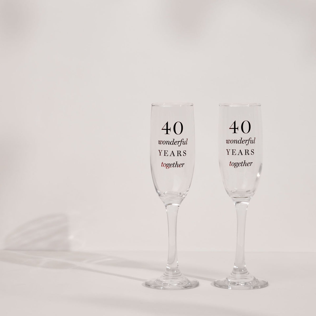 Two clear champagne flutes with '40 wonderful years together' anniversary print
