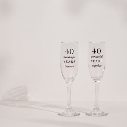 Two clear champagne flutes with '40 wonderful years together' anniversary print