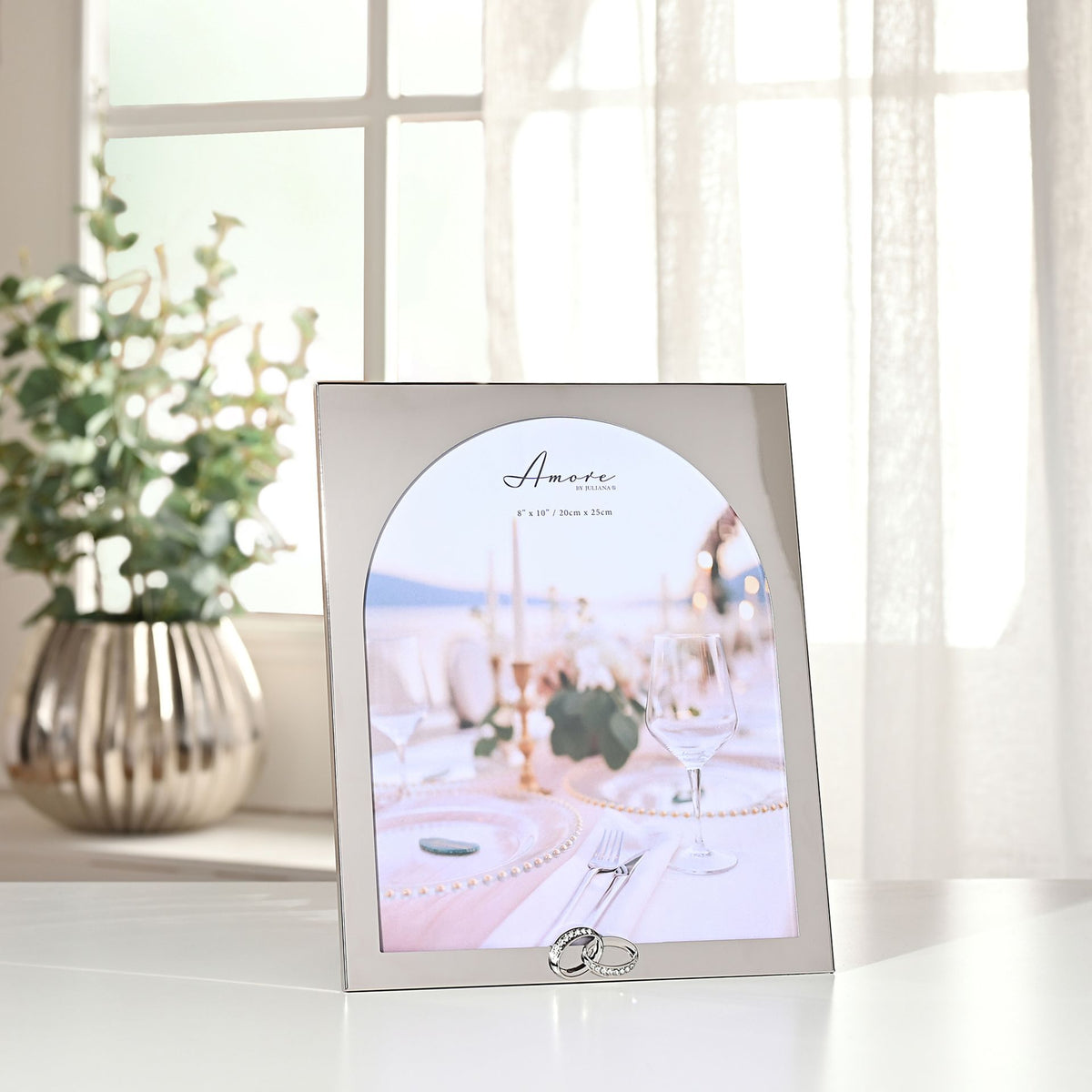 Arch photo frame with ring accent at bottom, silver-tone frame, standing on table