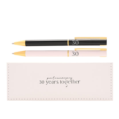Pair of pens, black and light pink, with gold rings and '30' marking