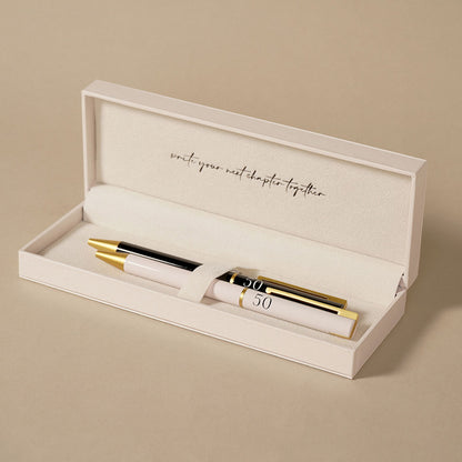 Open gift box holding two anniversary pens, black and pale pink with gold accents
