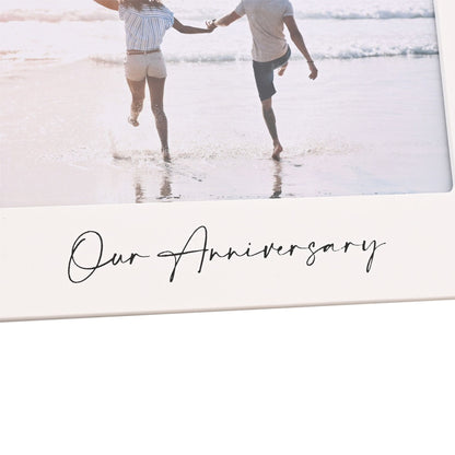 Close-up of white 6x4 anniversary photo frame with 'Our Anniversary' script below couple photo
