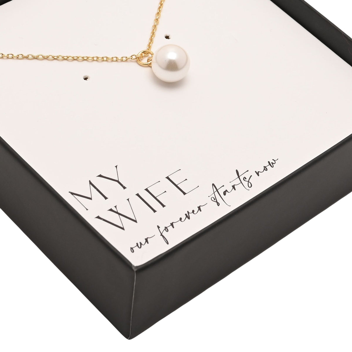 Close-up of faux pearl pendant on gold plated chain with gift box branding