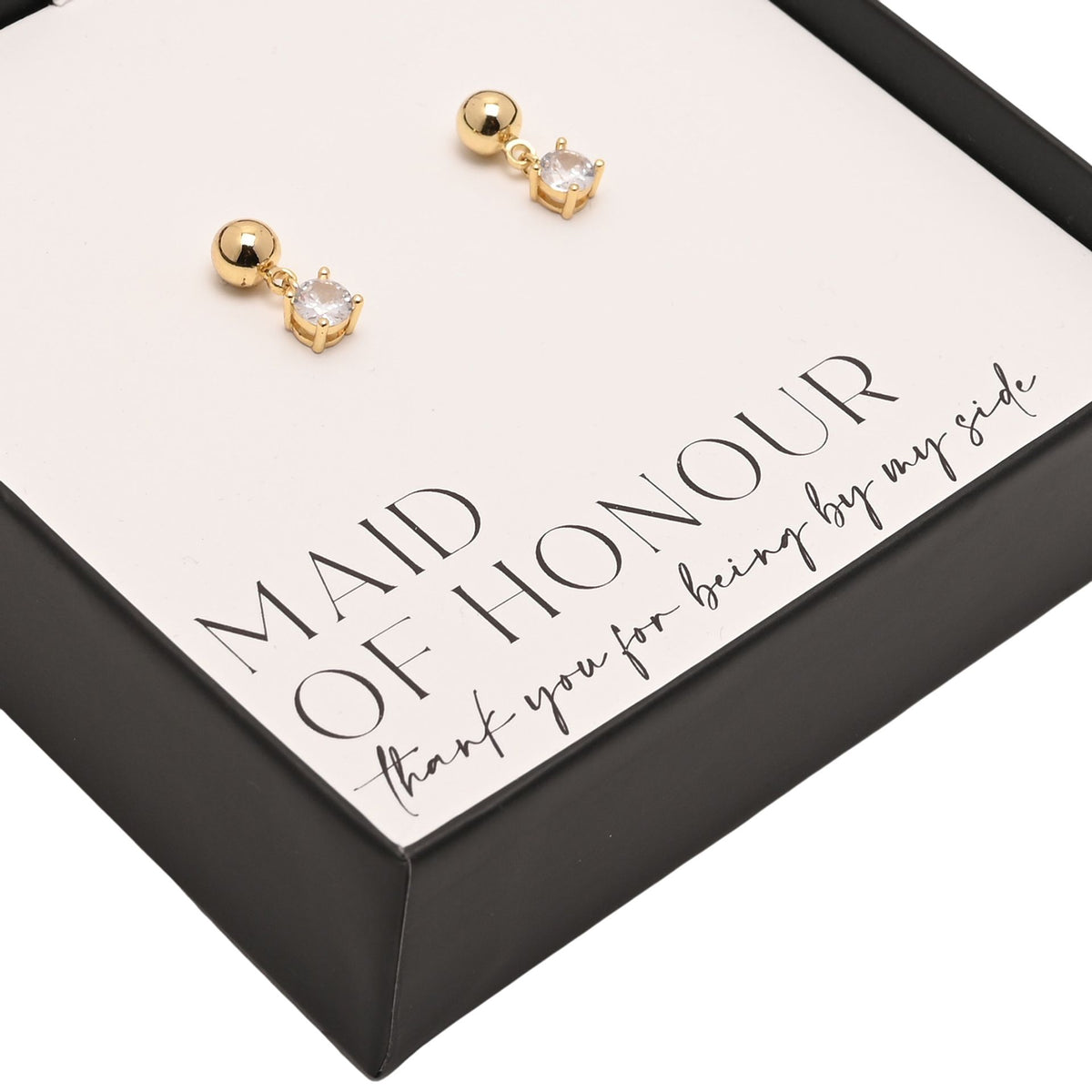 Close-up: gold-plated earrings with clear crystal heart charm and round studs