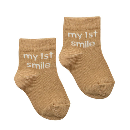 Pair of tan baby socks with "my 1st smile" text on cuff