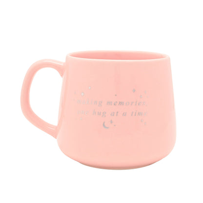 Pink ceramic mug with handle, “making memories, one hug at a time” print