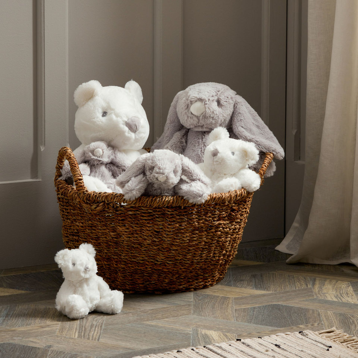 Plush bear set: two medium bears in wicker basket, small bear sitting on floor.