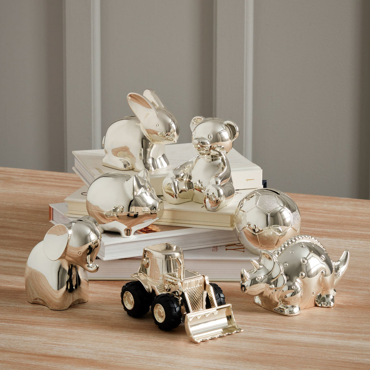 Silver-plated teddy bear money box figurines arranged with other metallic animals