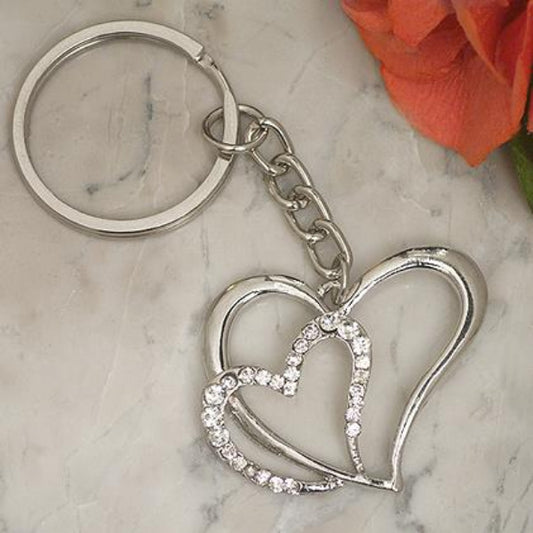 Silver-toned metal keychain with a round key ring, short chain, and interlocking double-heart pendant. The lower heart is outlined with small clear rhinestones.