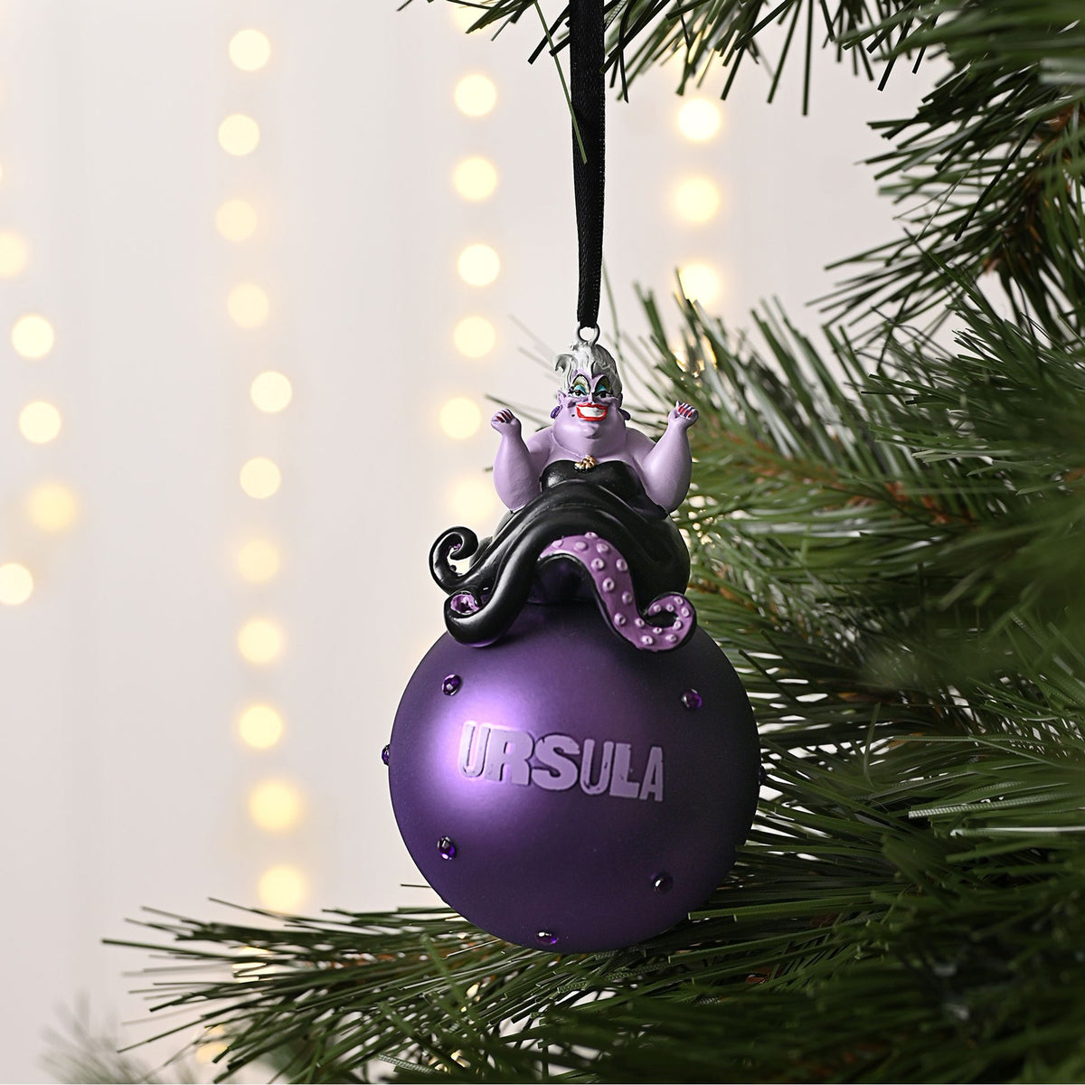 Purple Ursula glass bauble hanging on a ribbon with 'URSULA' text