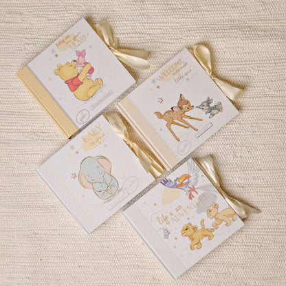 Assorted mini photo albums with Disney-themed baby illustrations and ribbon ties