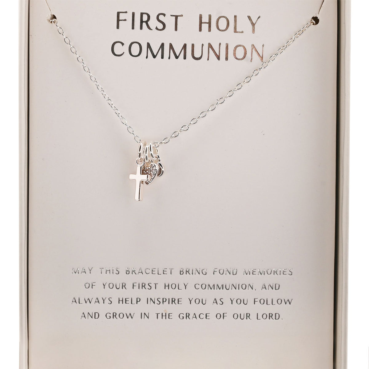 Silver cross pendant on a First Holy Communion necklace chain, shown on card