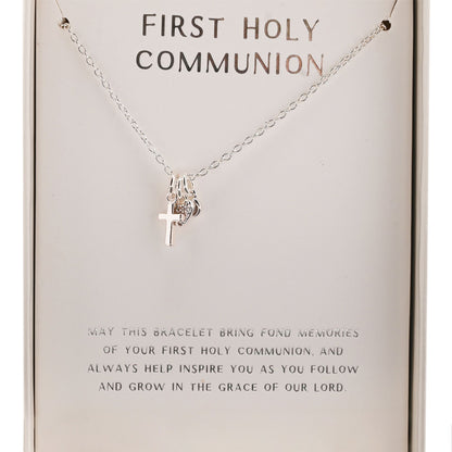 Silver cross pendant on a First Holy Communion necklace chain, shown on card