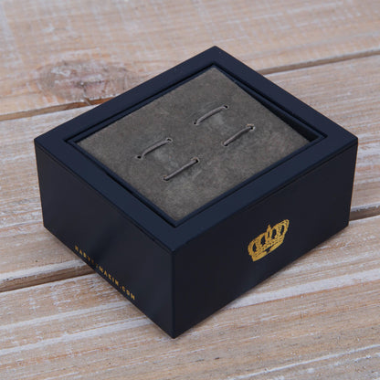Car cufflinks laid out on gray insert in presentation box, metal posts visible