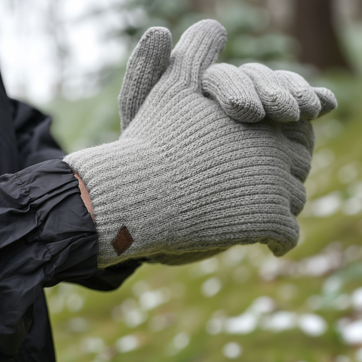 Grey knit glove with ribbed cuff and small leather logo patch