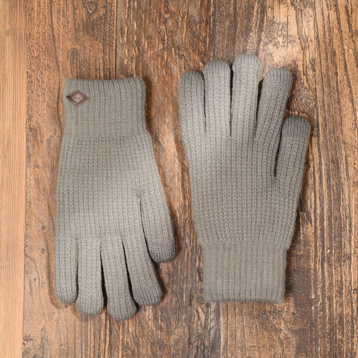 Pair of grey knit gloves with ribbed cuffs and leather logo patches