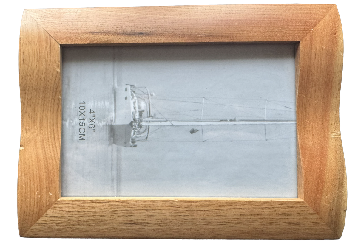 A rectangular wooden picture frame with a light oak finish, showing markings fro display usage.