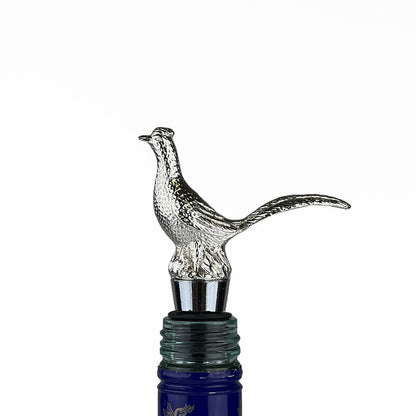 Silver bird finial bottle stopper with long tail, mounted on dark bottle neck