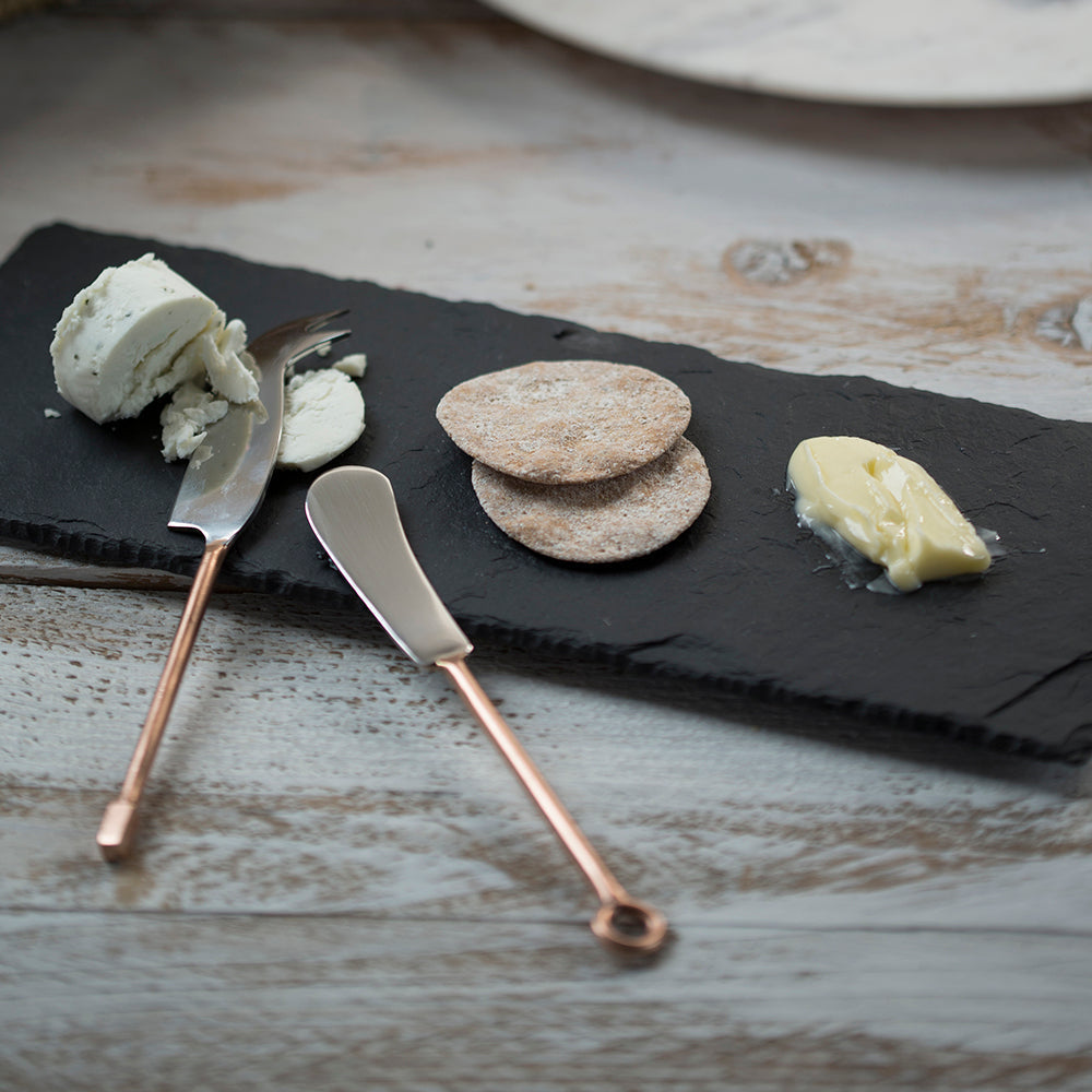 Set of 2 copper-handled cheese knives with dark blades and curved cutting edges