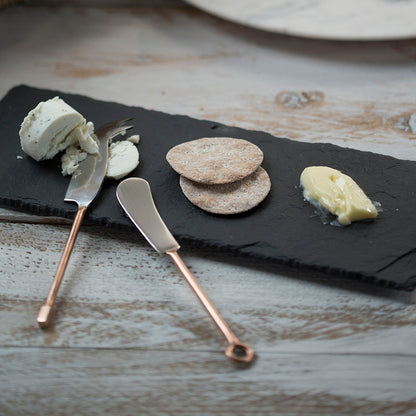 Set of 2 copper-handled cheese knives with dark blades and curved cutting edges