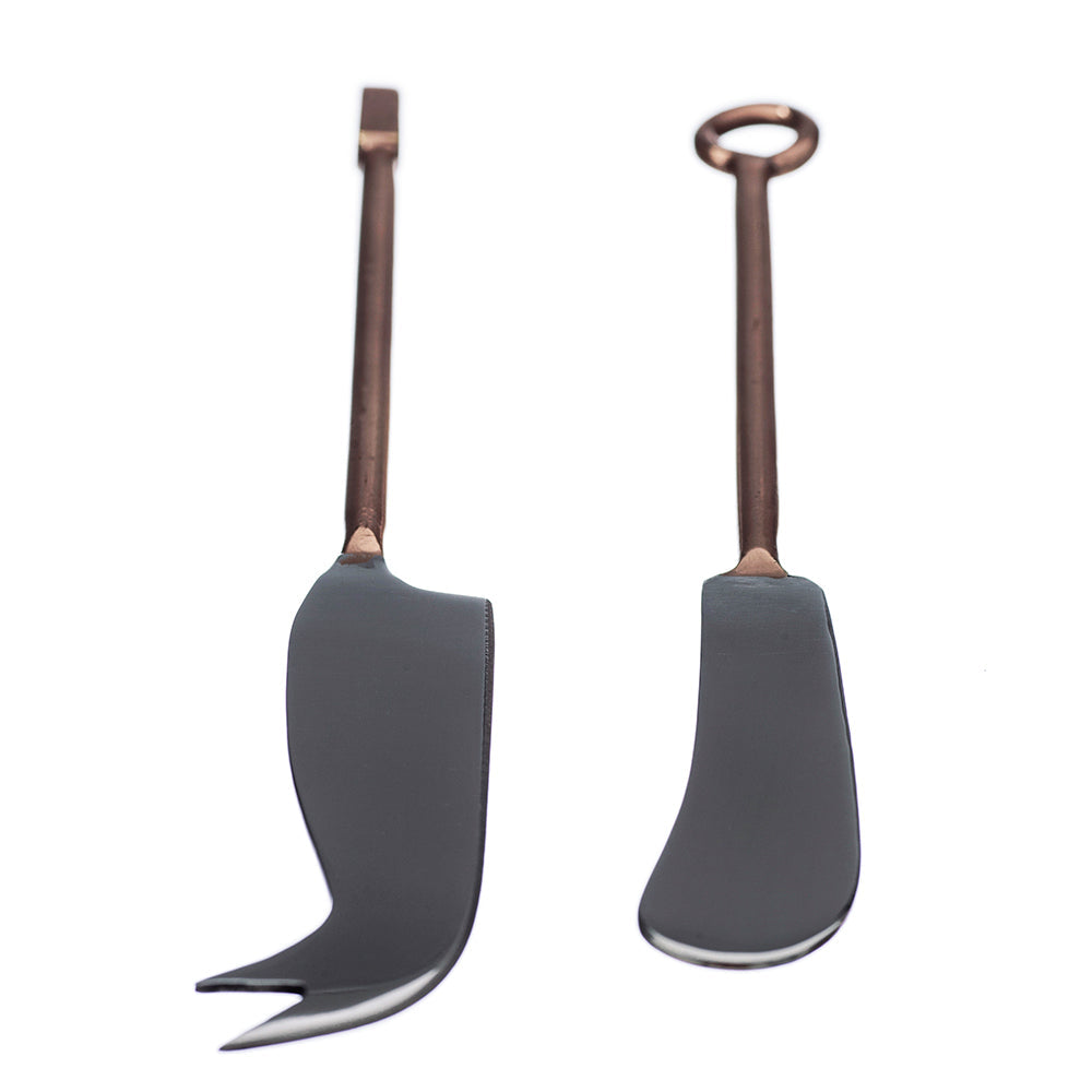 Two cheese knives with dark handles and copper-colored stems, curved for serving