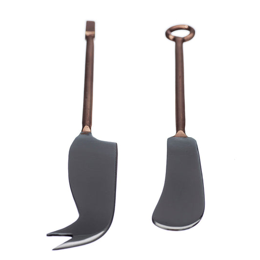 Two cheese knives with dark handles and copper-colored stems, curved for serving