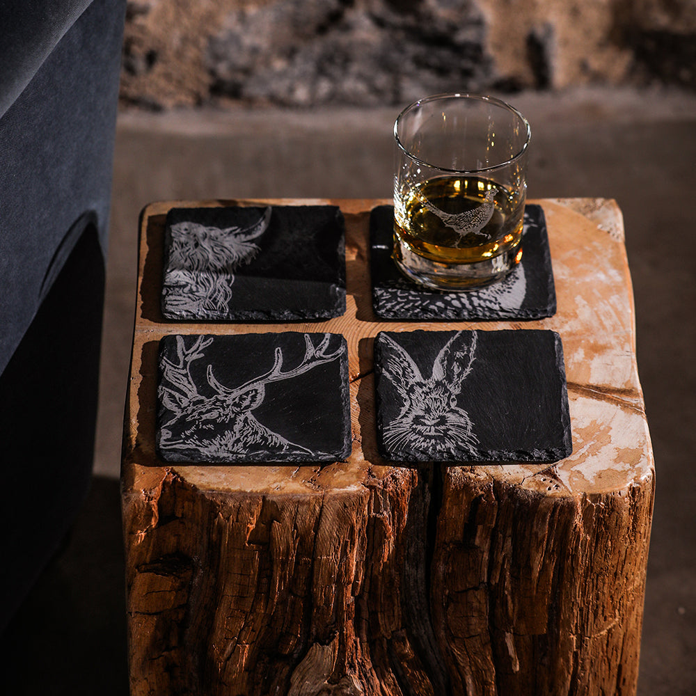 Set of 4 slate coasters with black animal silhouettes and white engravings