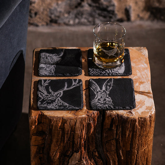 Set of 4 slate coasters with black animal silhouettes and white engravings