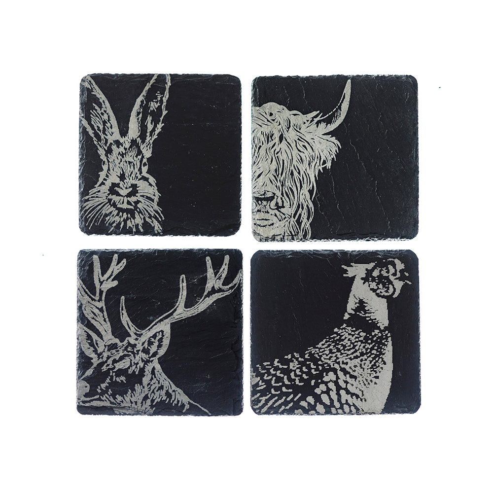 Four black slate coasters featuring white engravings of rabbit, deer, and fawn