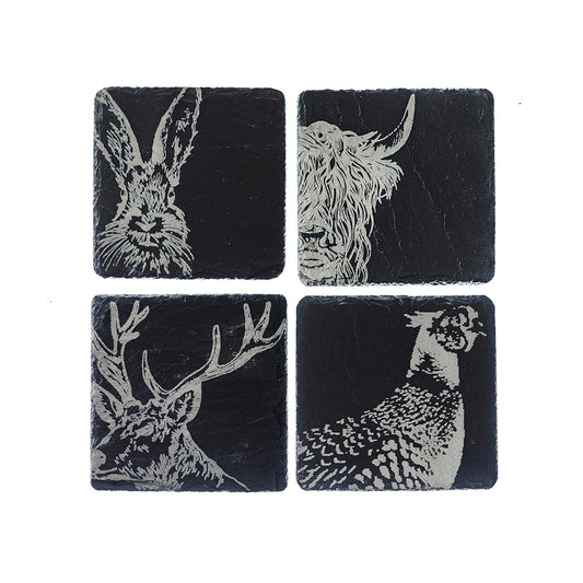 Four black slate coasters featuring white engravings of rabbit, deer, and fawn