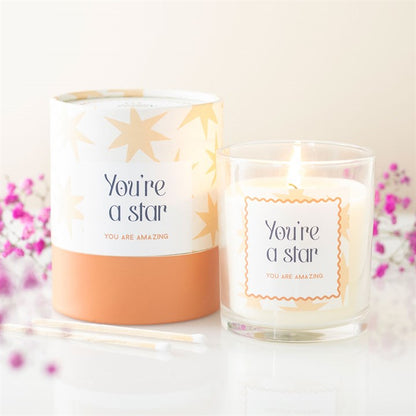 Star-themed scented candle set: two glass jars with star-pattern labels and visible wicks
