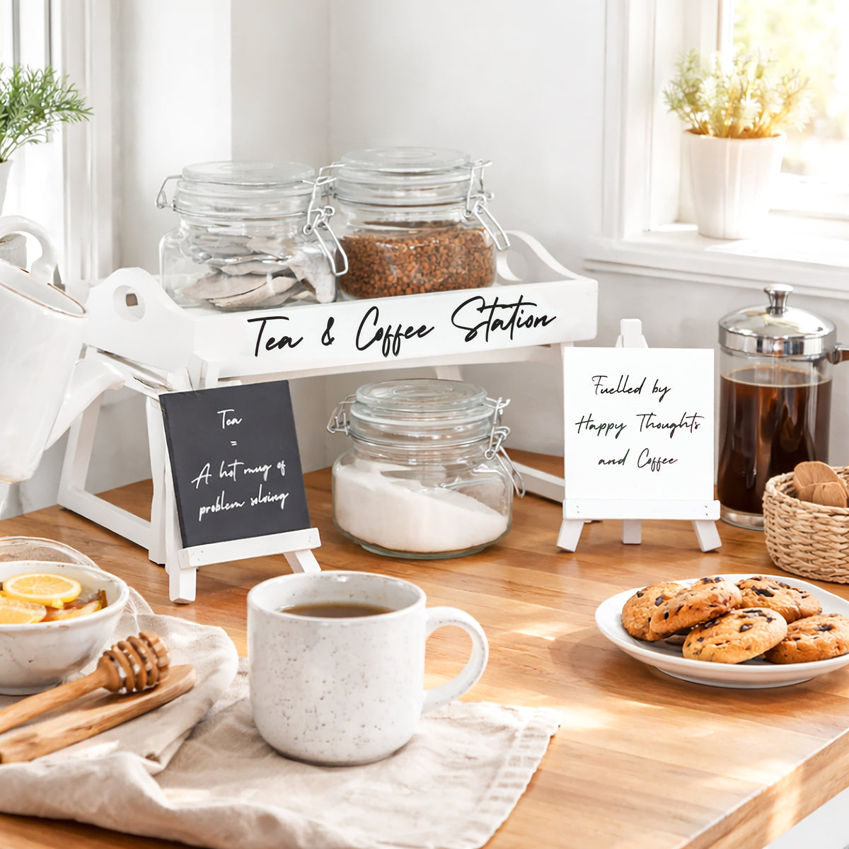 Tea and coffee station with jars, teapot, mugs, and chalk easel signs