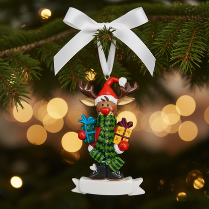 A festive Christmas ornament featuring a cartoon reindeer wearing a red Santa hat and a green patterned sweater, holding wrapped presents on a white scroll base.