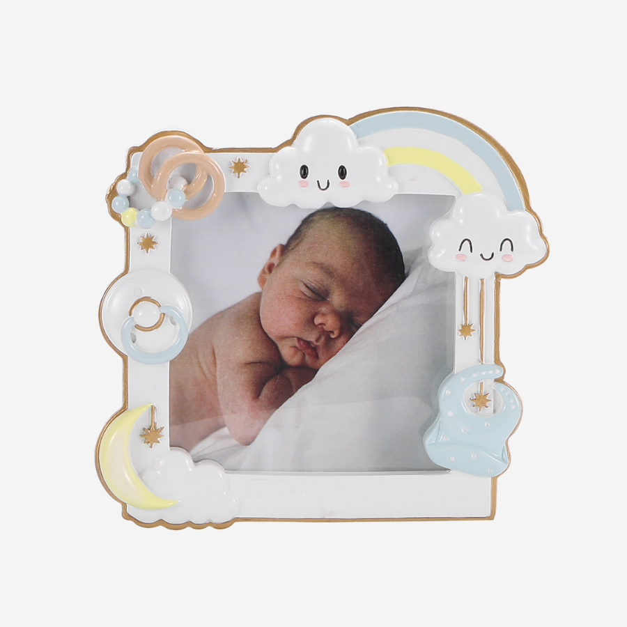 A decorative baby photo frame with a whimsical pastel design, featuring a sleeping baby photo insert, a smiling cloud, a rainbow, a crescent moon, stars, and a small blue cloud with a star. The frame is shown on a clean white background.