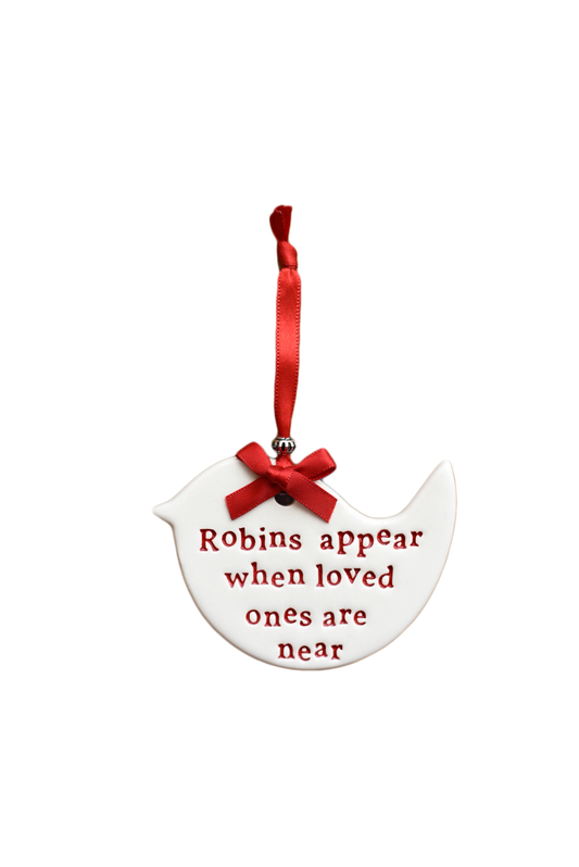 A white ceramic bird-shaped hanging ornament with red embroidered text reading 'Robins appear when loved ones are near' and a red ribbon loop at the top, shown on a plain white background.