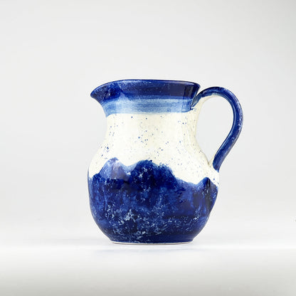 Blue ceramic jug with speckled white top and wave-style darker blue base