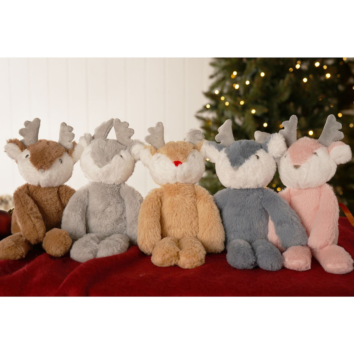 Assorted plush reindeer figures on a red fabric surface, visible mixed colors