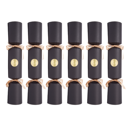 Six black cylindrical party crackers arranged in two rows on a plain white background, each tied with a metallic rose-gold ribbon and featuring a round gold emblem on the front.