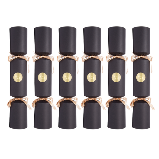 Six black cylindrical party crackers arranged in two rows on a plain white background, each tied with a metallic rose-gold ribbon and featuring a round gold emblem on the front.
