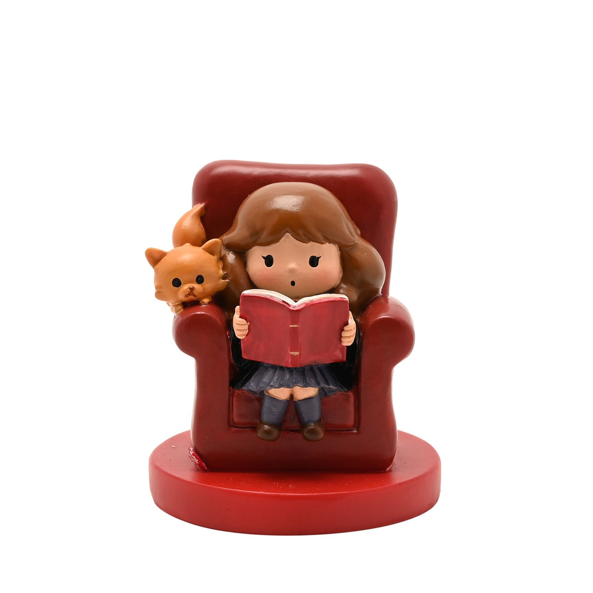 Child and small orange pet sitting in red armchair figurine holding a red book