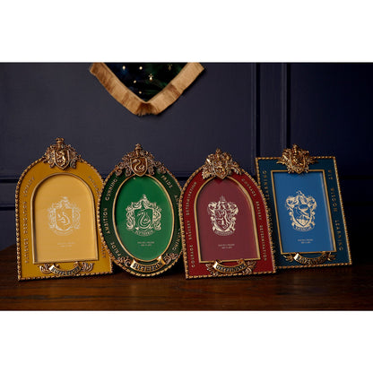 Shelf display of multiple house crest photo frames, including a blue Ravenclaw frame